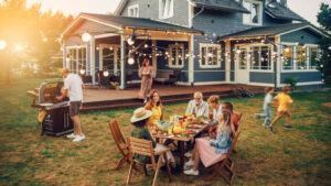 Big Family and Friends Celebrating Outside at Home. Diverse Group of Children, Adults and Old People Gathered at a Table, Having Fun Conversations. Preparing Barbecue and Eating Vegetables.